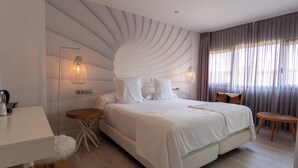 Een moderne slaapkamer met een groot bed, nachtkastjes en een bureau.