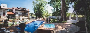 Ein Poolbereich mit Whirlpool, Liegestühlen und einer Steindeckterrasse.