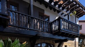 Een gebouw met een balkon, stenen muren en bloempotten.