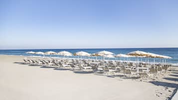 Playa privada, sillas reclinables de playa, sombrillas