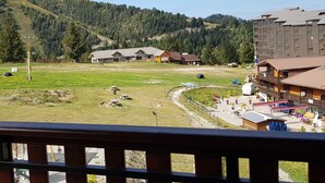 A hotel with multiple buildings, a grassy field, and a forested hillside in the background. - Résidence Les Blanches Provençales (Selonnet)