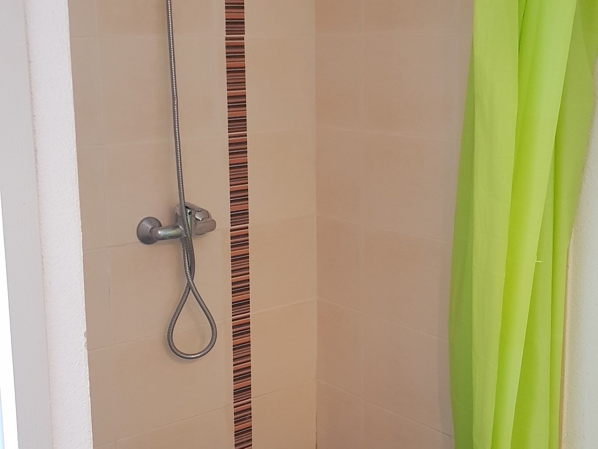 Doccia con soffione a muro e doccetta manuale.