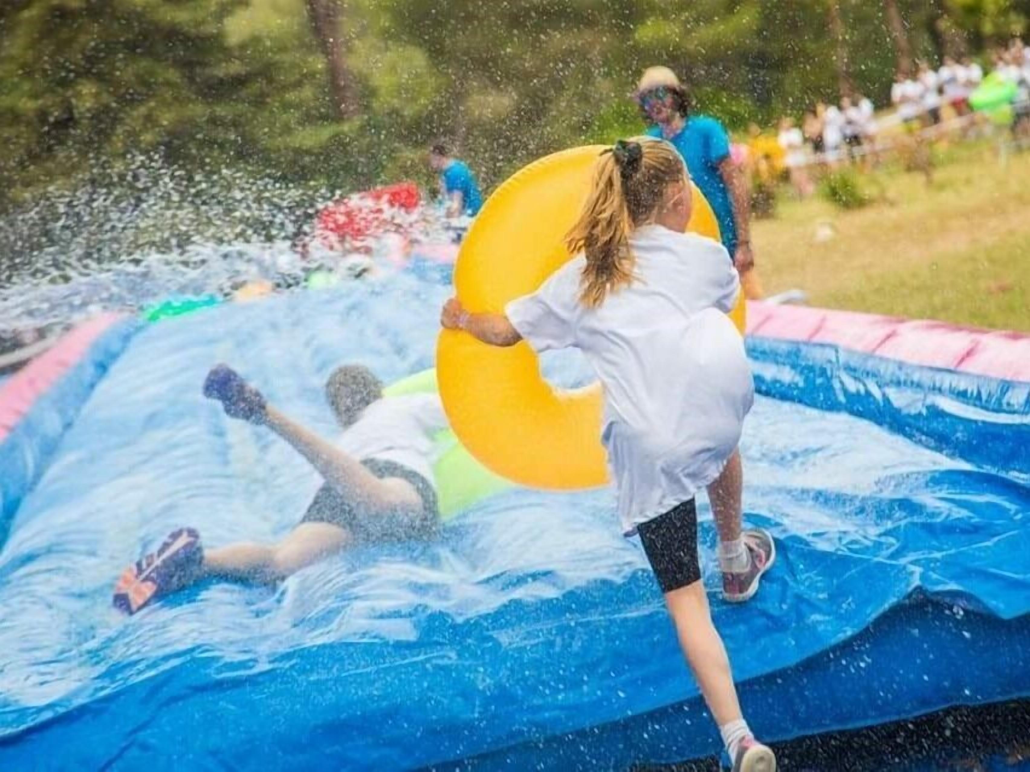 A water slide with people sliding down.