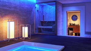 Un espace spa moderne doté d’une piscine chauffée, d’un sauna en bois et d’un coin salon confortable agrémenté d’une horloge murale.