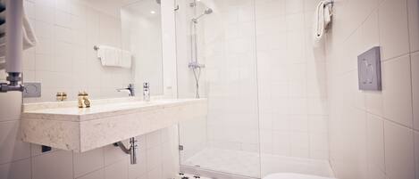 Un baño moderno con ducha, inodoro y tocador.