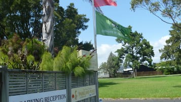 A sign for a parking/reception area with a flag and a sign for a parkland place.