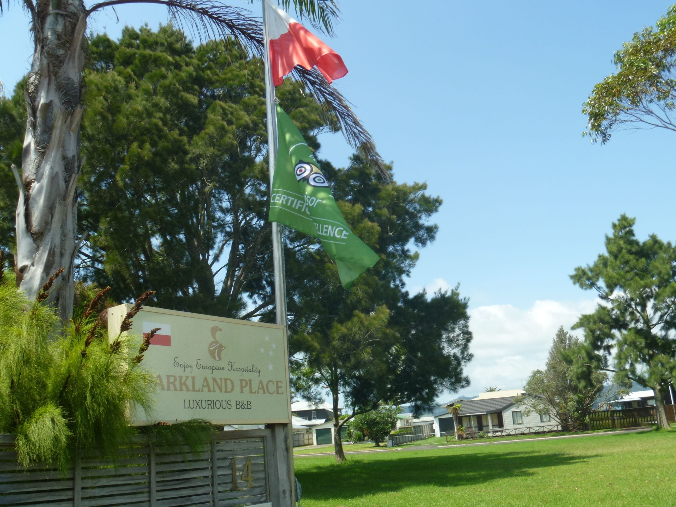 Un letrero que dice 'ARKLAND PLACE' con un asta de bandera ondeando una bandera y un certificado.