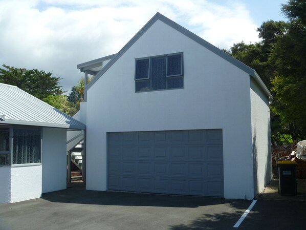 A single-story building with a garage, a small window, and a sloped roof.