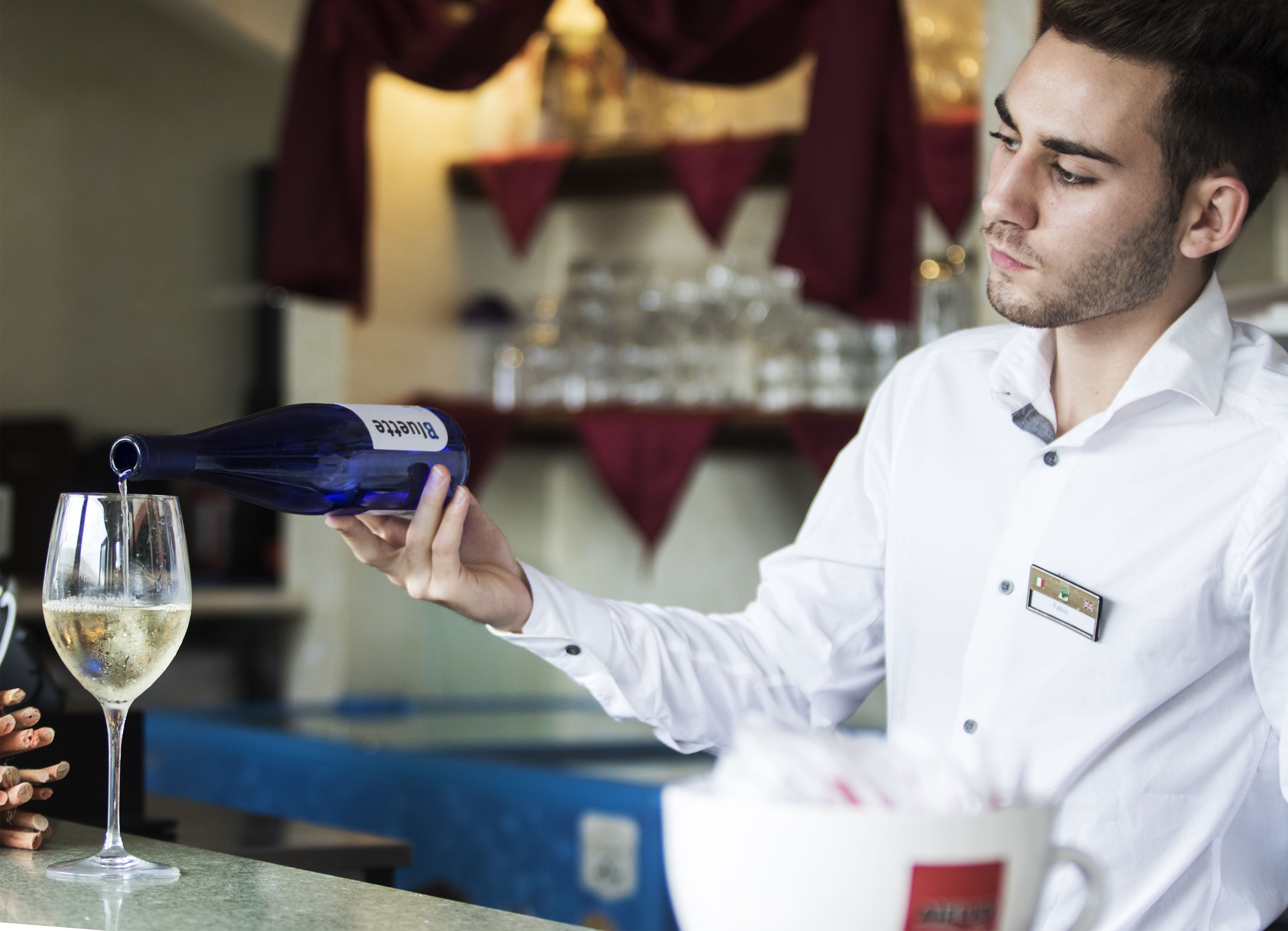 Une personne qui verse une boisson dans un verre.
