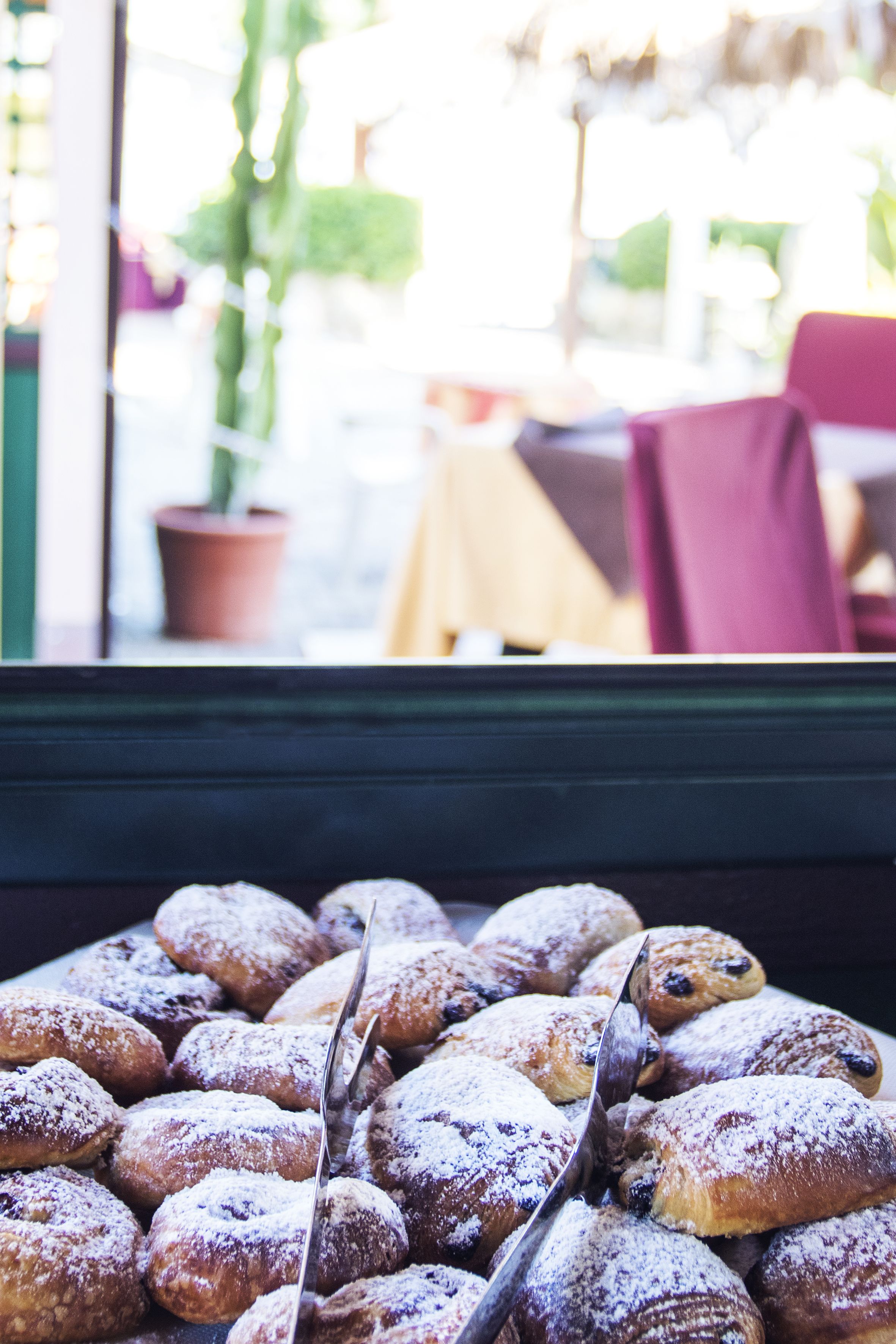 A display of pastries dusted with powdered sugar.