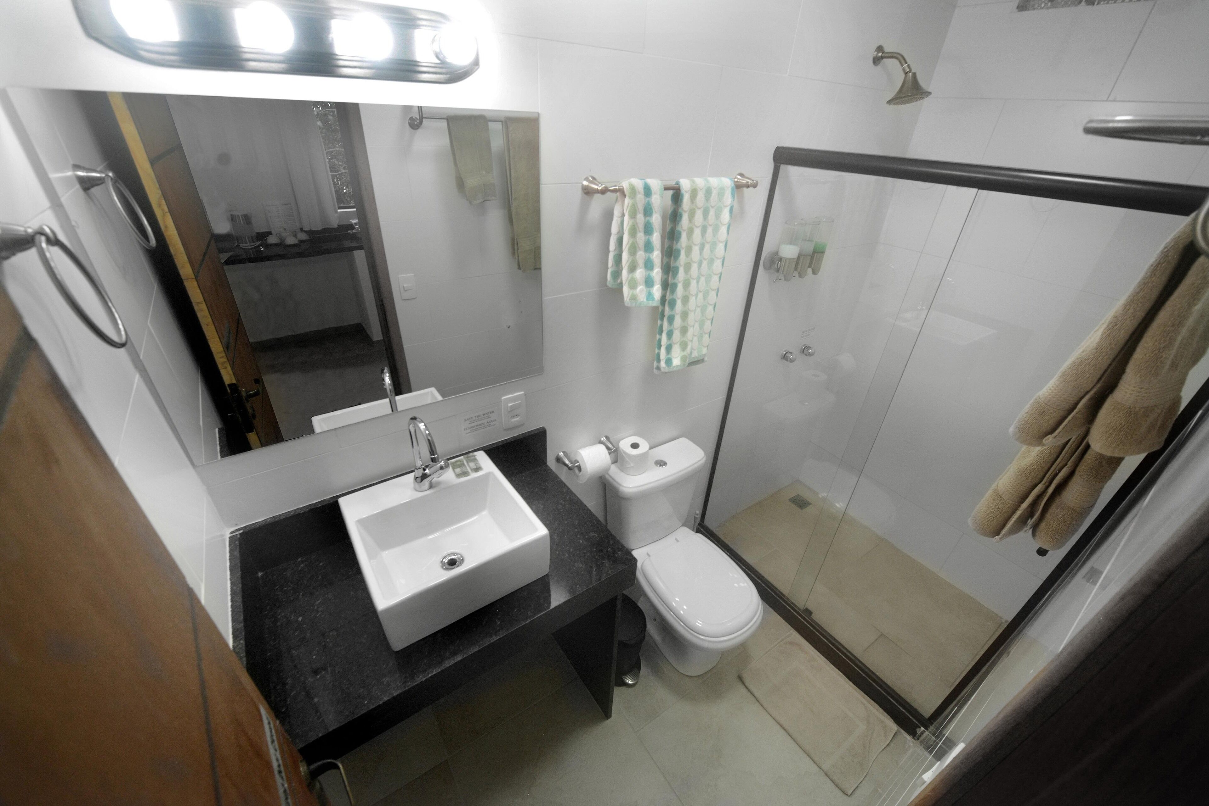A bathroom with a sink, toilet, and glass-enclosed shower.