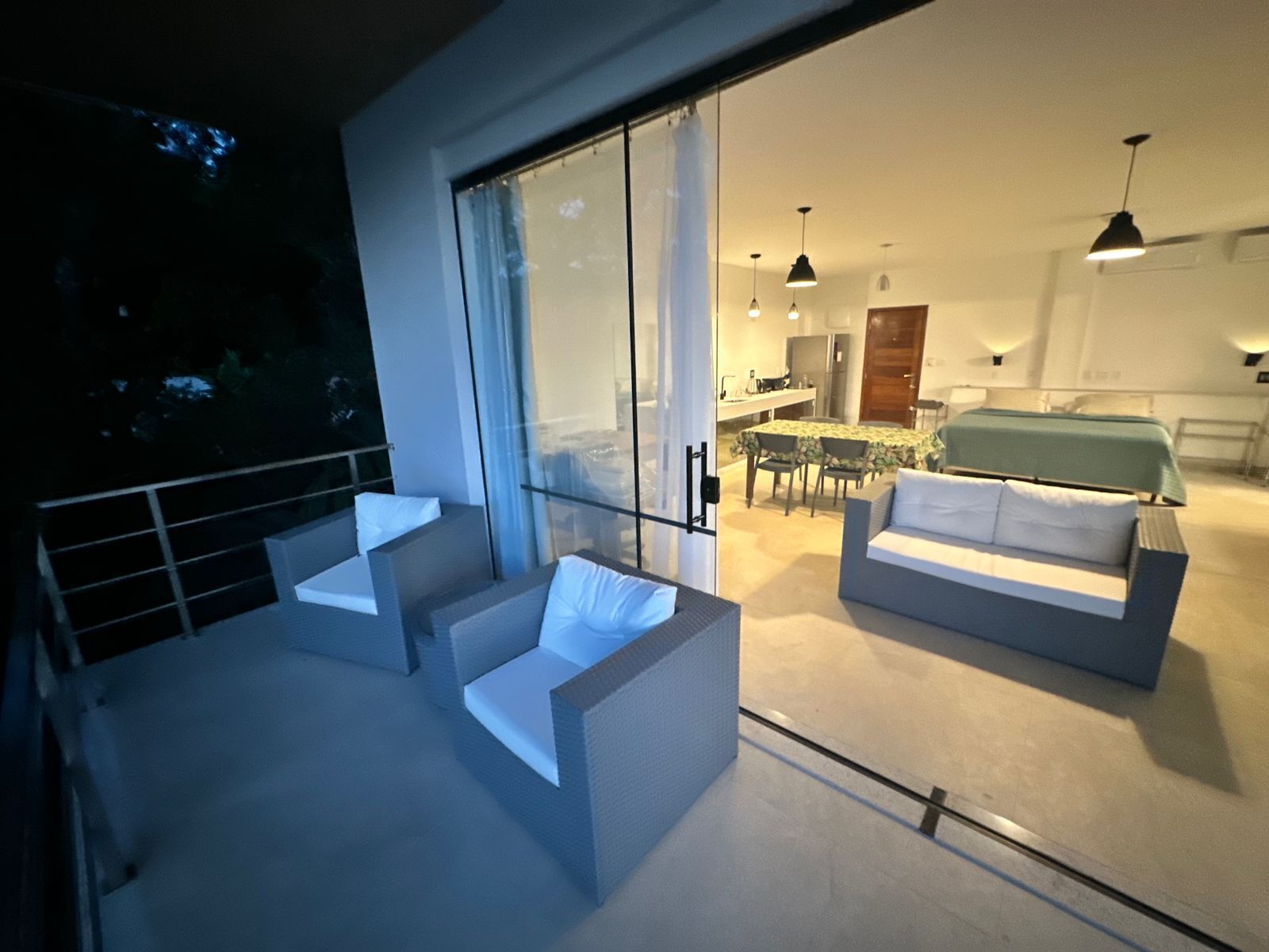 Un intérieur moderne avec un balcon, un coin repas et une chambre.