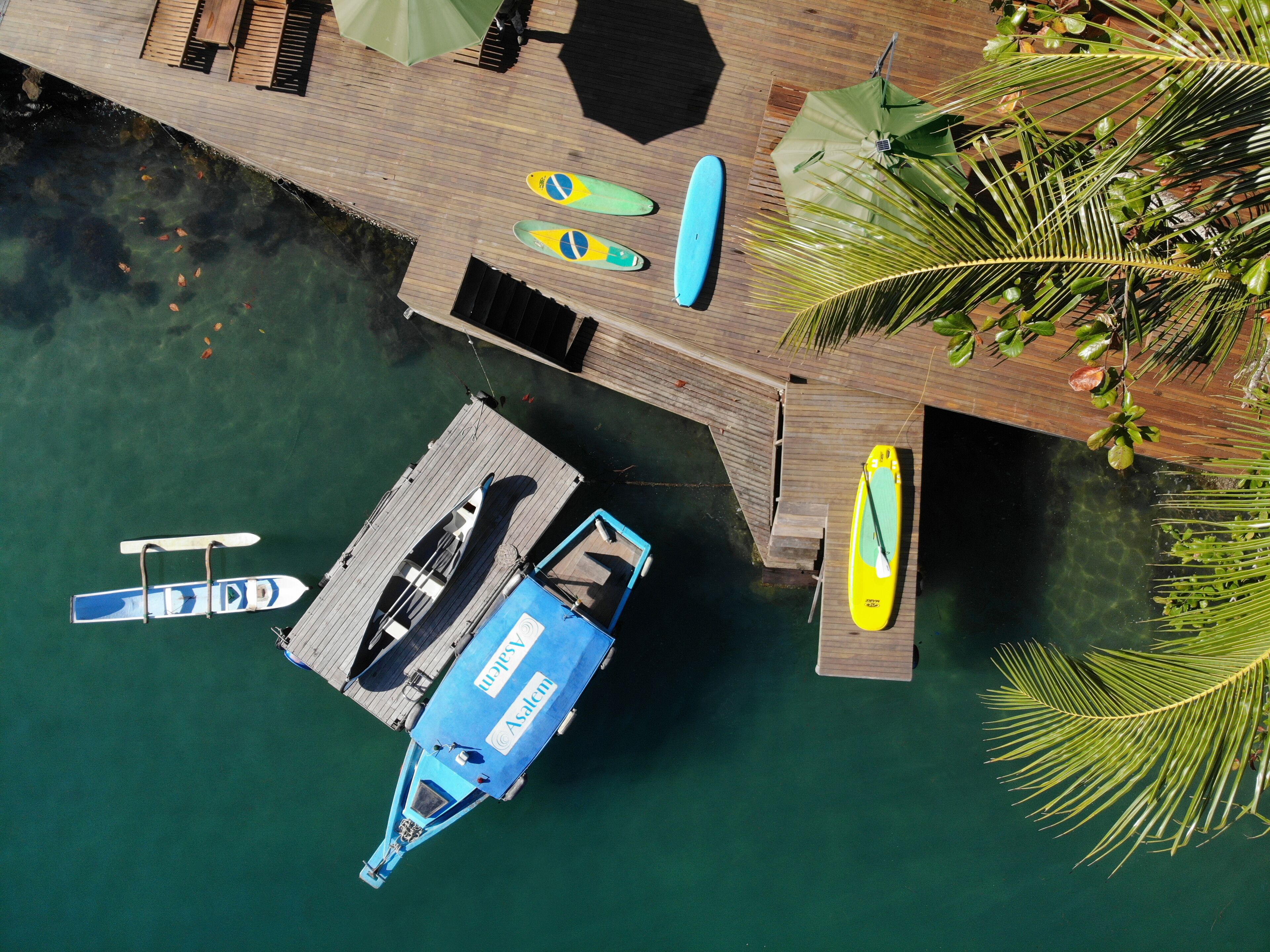 A wooden dock with kayaks and a boat.