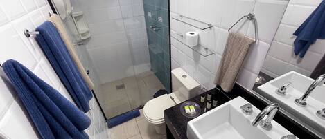 A modern bathroom with a glass-enclosed shower, a toilet, a sink, and a mirror.