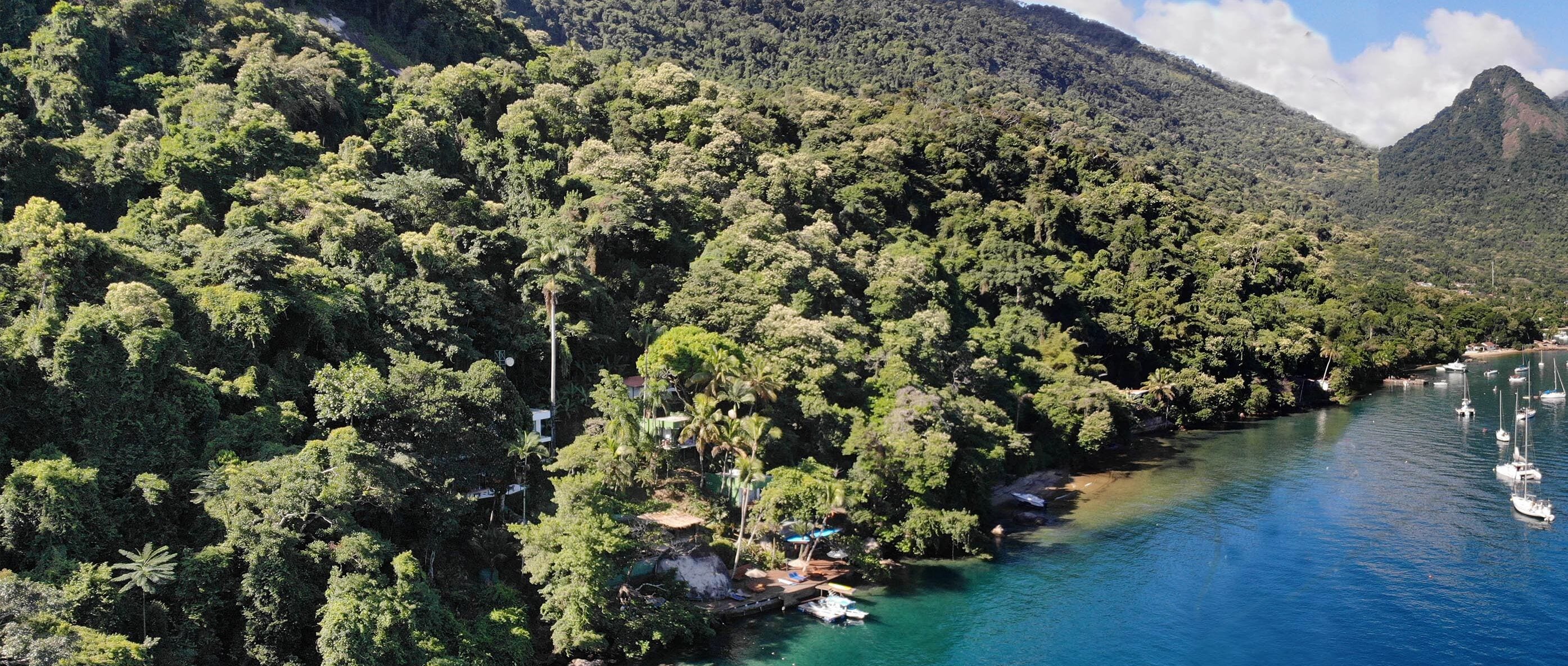 Une rivière où l’on peut naviguer, bordée d’une forêt dense et entourée de montagnes.
