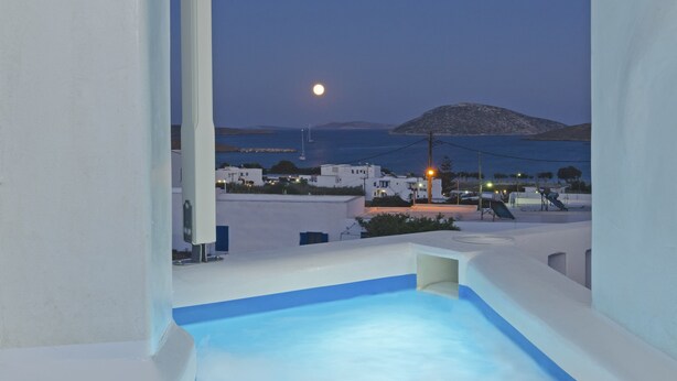 A pool area with a view of a moonlit sea and distant island. - Castillio Hotel (Astypalaia)
