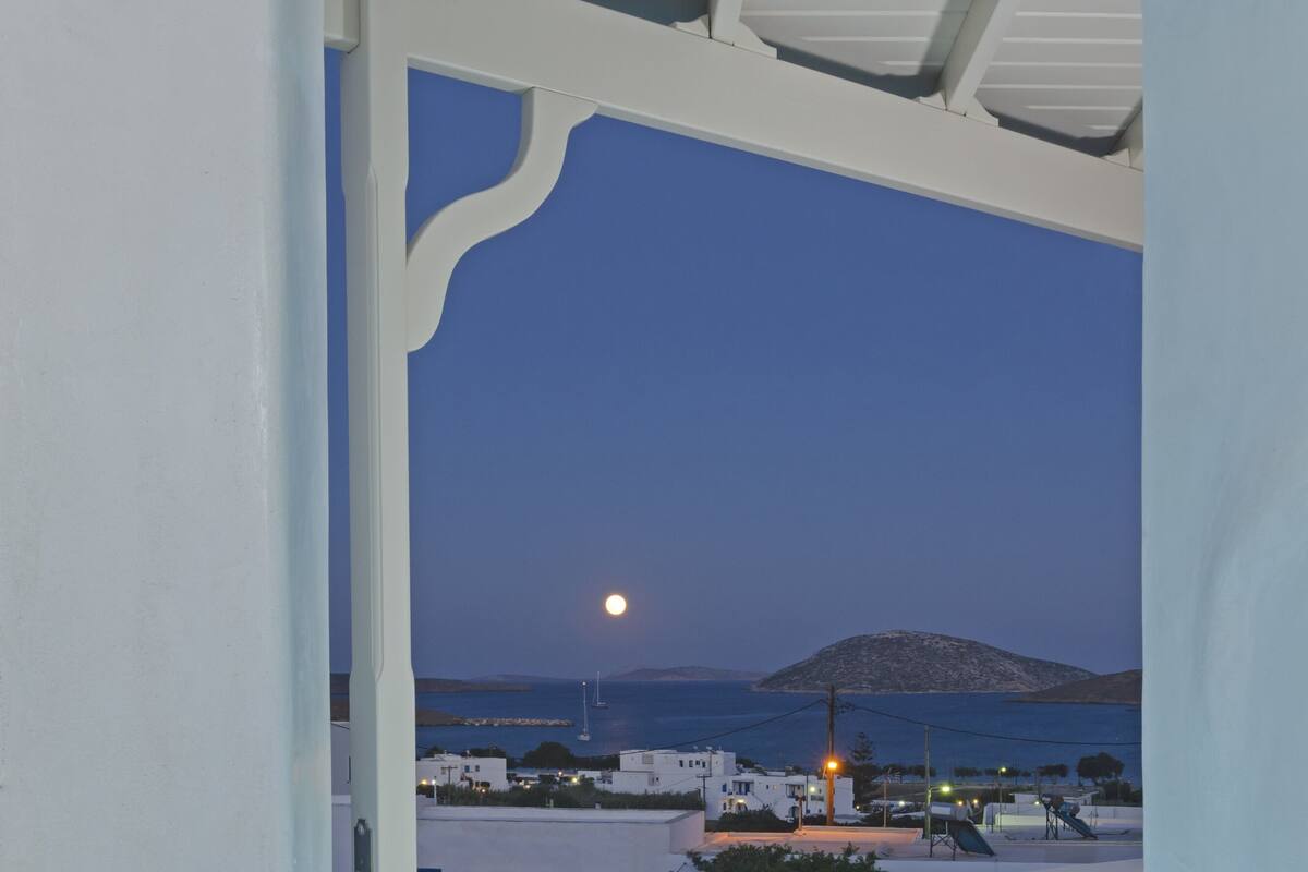 A pool area with a view of a moonlit sea and distant island.