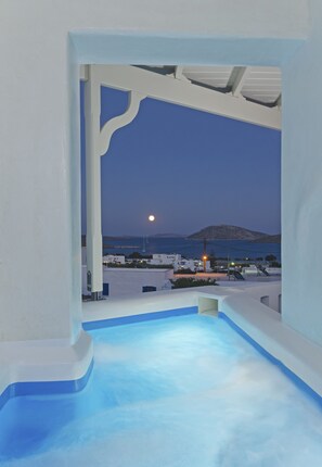 A pool area with a view of a moonlit sea and distant island. - Castillio Hotel (Astypalaia)