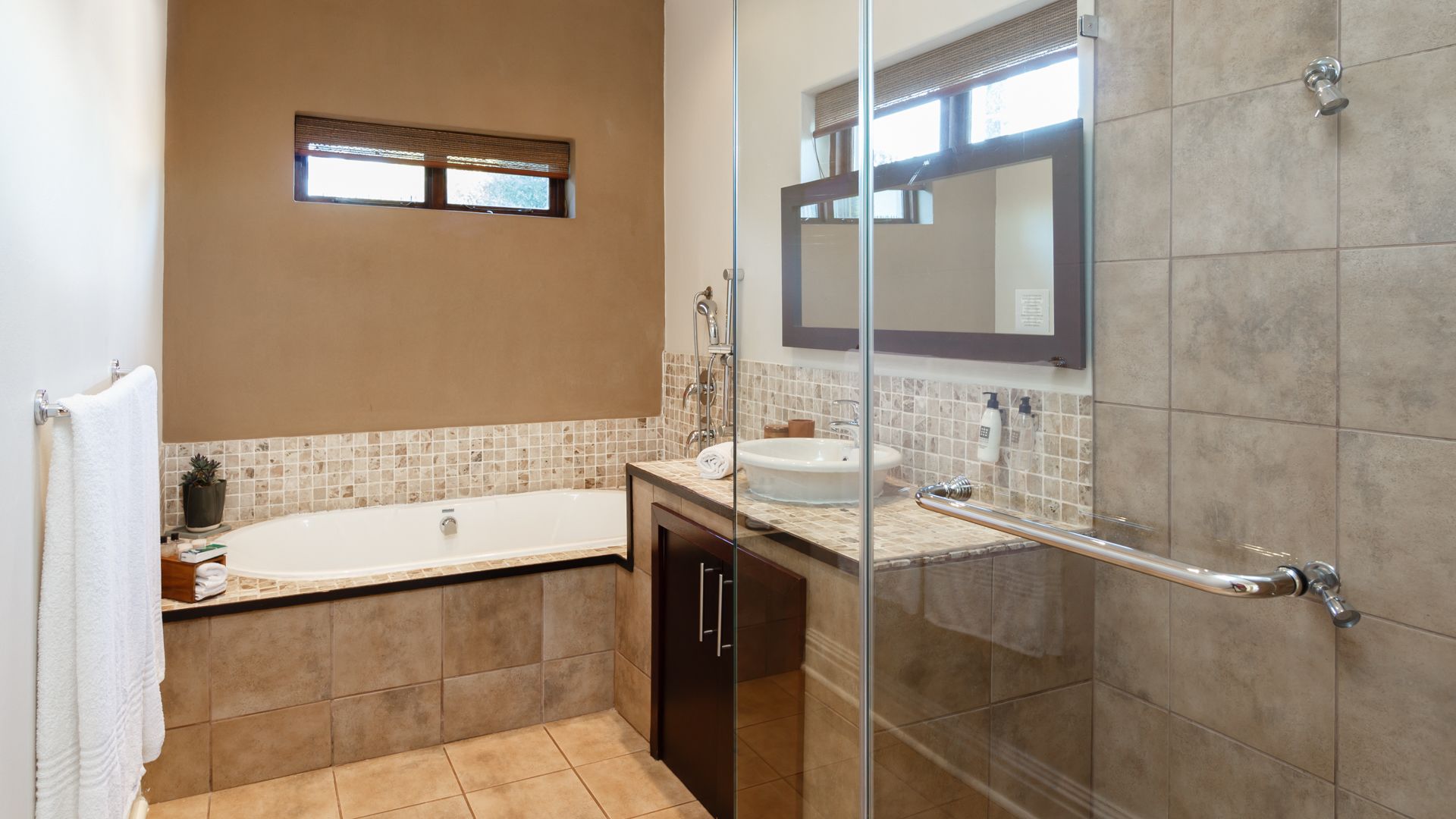 Un baño moderno con cabina de ducha de vidrio, bañera y tocador con lavabo.