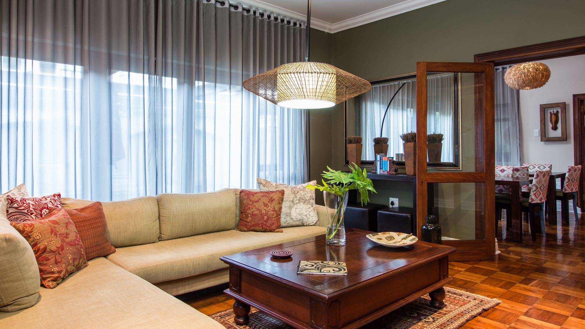 A living room with a sofa, coffee table, and a dining area with chairs and a table.