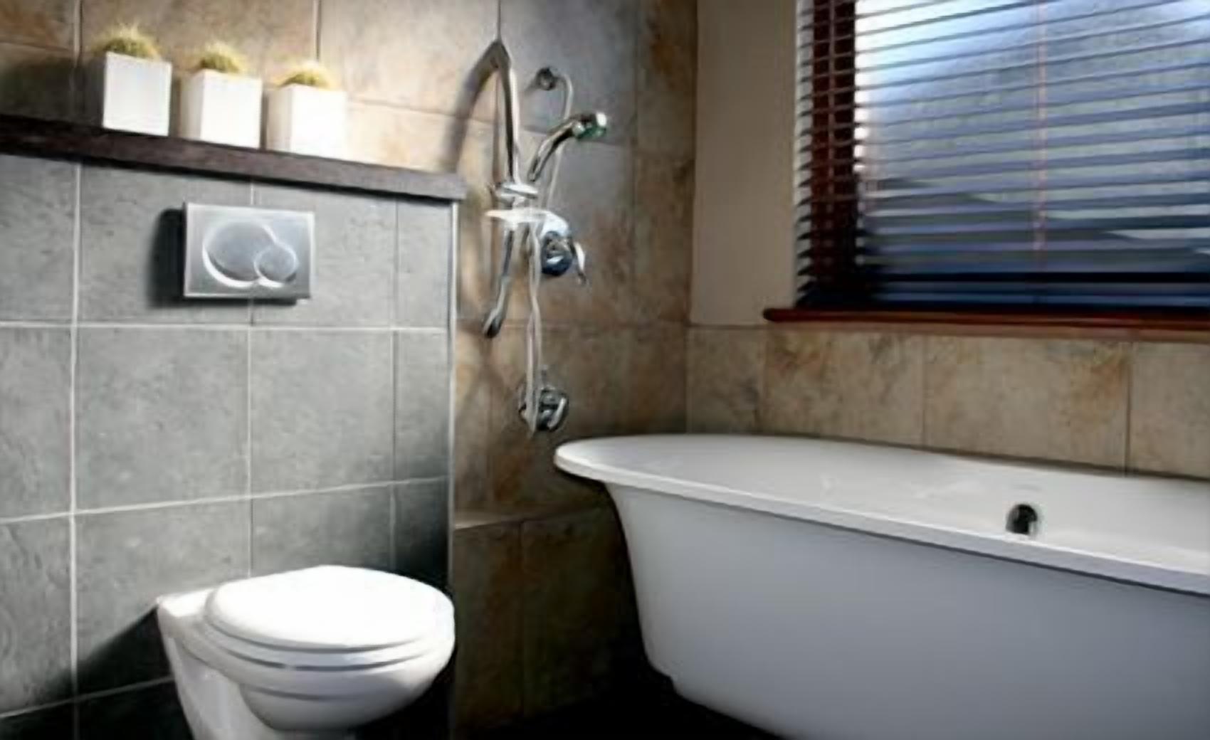 A bathroom with a toilet, a bathtub, and a shower.