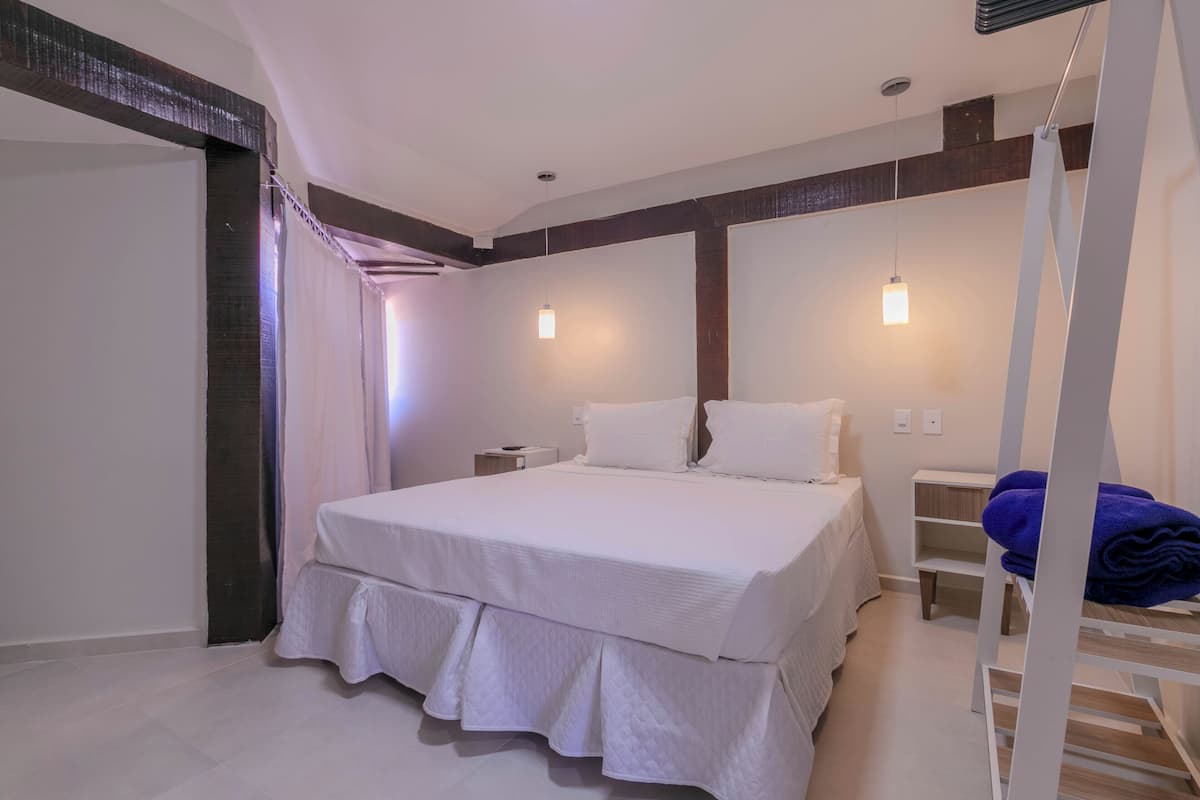 Une chambre à coucher moderne avec un grand lit, des tables de chevet et une armoire.