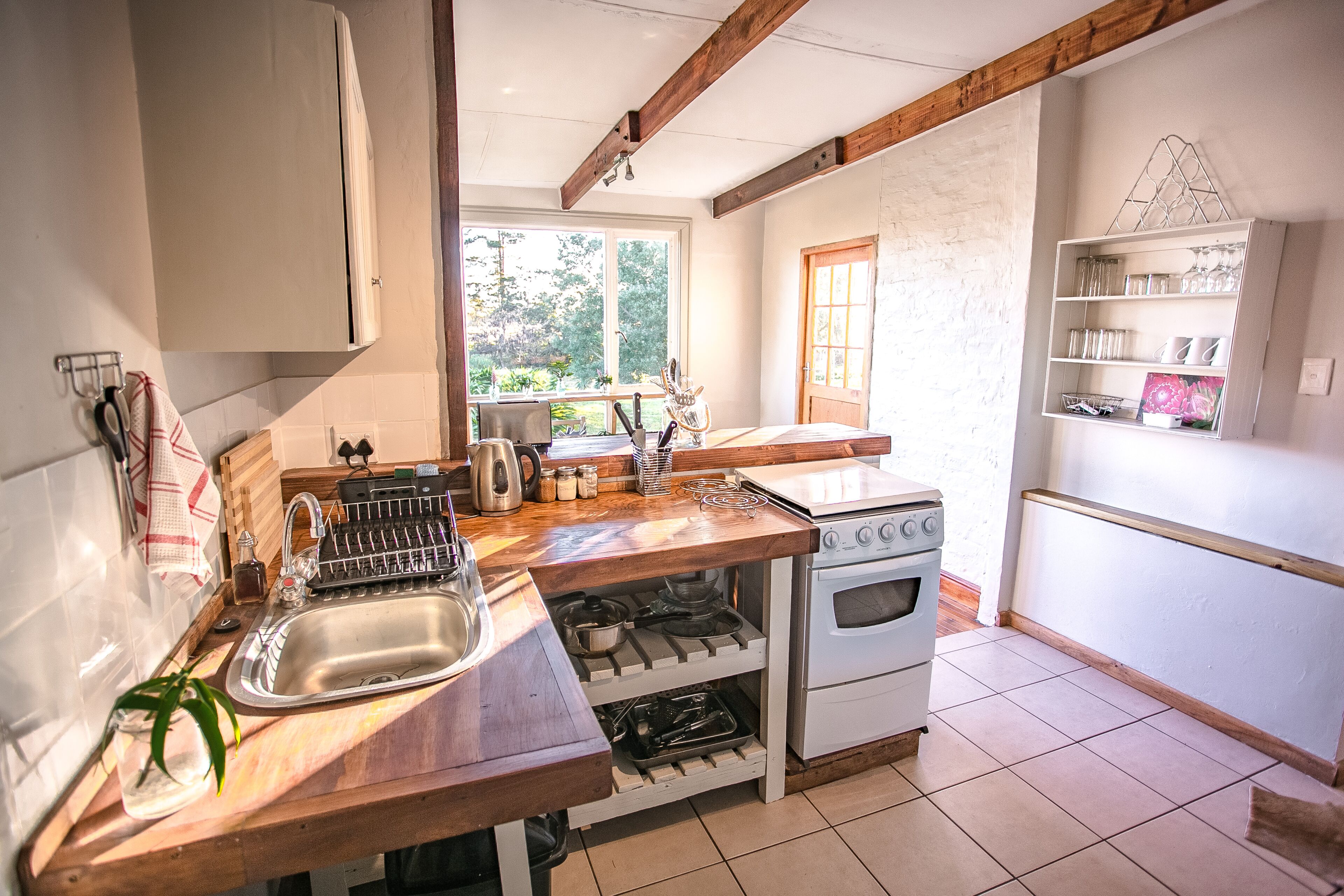 Une cuisine avec des plans de travail en bois, un évier, une cuisinière et une fenêtre.
