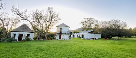A rural property with a large grassy field, a white house with a thatched roof, and a barn labeled "Old Dairy."
