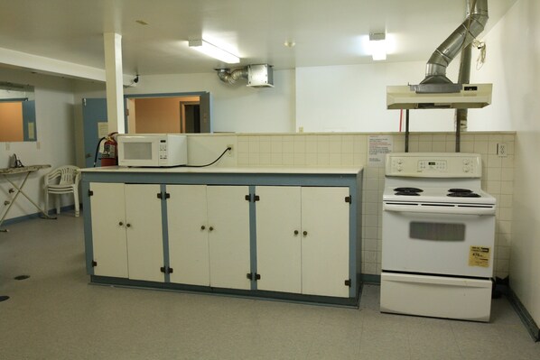Una cocina equipada con microondas, estufa y armarios.