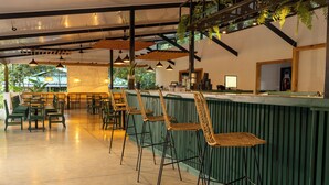 A restaurant with high tables and chairs, a counter, and hanging plants. - Natural Lodge Caño Negro (Caño Negro)