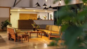 A lobby with wooden furniture, a reception desk, and potted plants. - Natural Lodge Caño Negro (Caño Negro)
