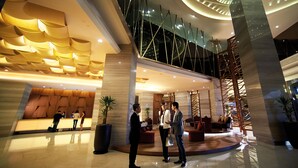 A modern lobby with a high ceiling, a reception desk, and a seating area. - Resorts World Genting - Genting Grand (Genting Highlands)