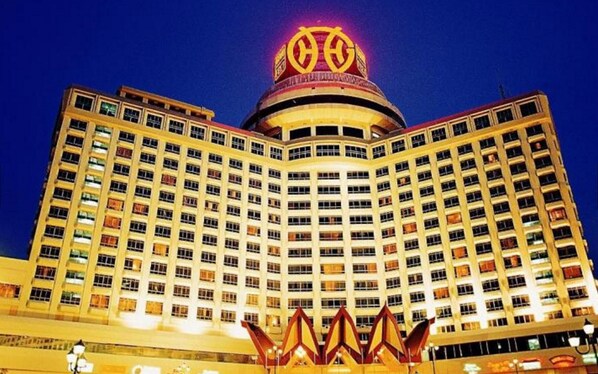 A multi-story hotel with a distinctive circular top and a series of balconies. - Resorts World Genting - Genting Grand (Genting Highlands)