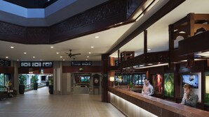 Un'ampia hall con soffitto alto, una reception e vista sull'esterno grazie a ampie finestre.