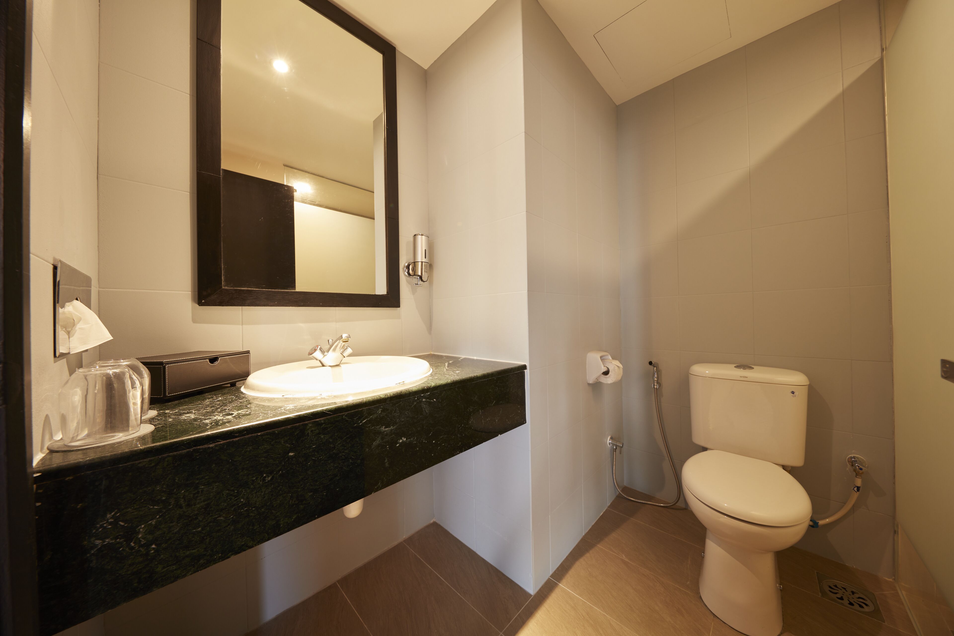 A bathroom with a sink, mirror, toilet, and shower.