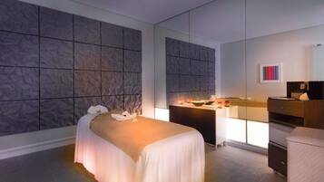 Una habitación de hotel moderna con una cama grande, un escritorio con una computadora y un espejo.