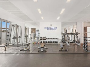 A gym with various exercise equipment, a wall clock, and a sign that reads 'IN BALANCE BY NOVOTEL.' - Novotel Abu Dhabi Al Bustan (Abu Dhabi)