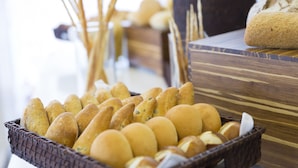 Un panier contenant divers types de pains et de petits pains, posé sur une table en bois.