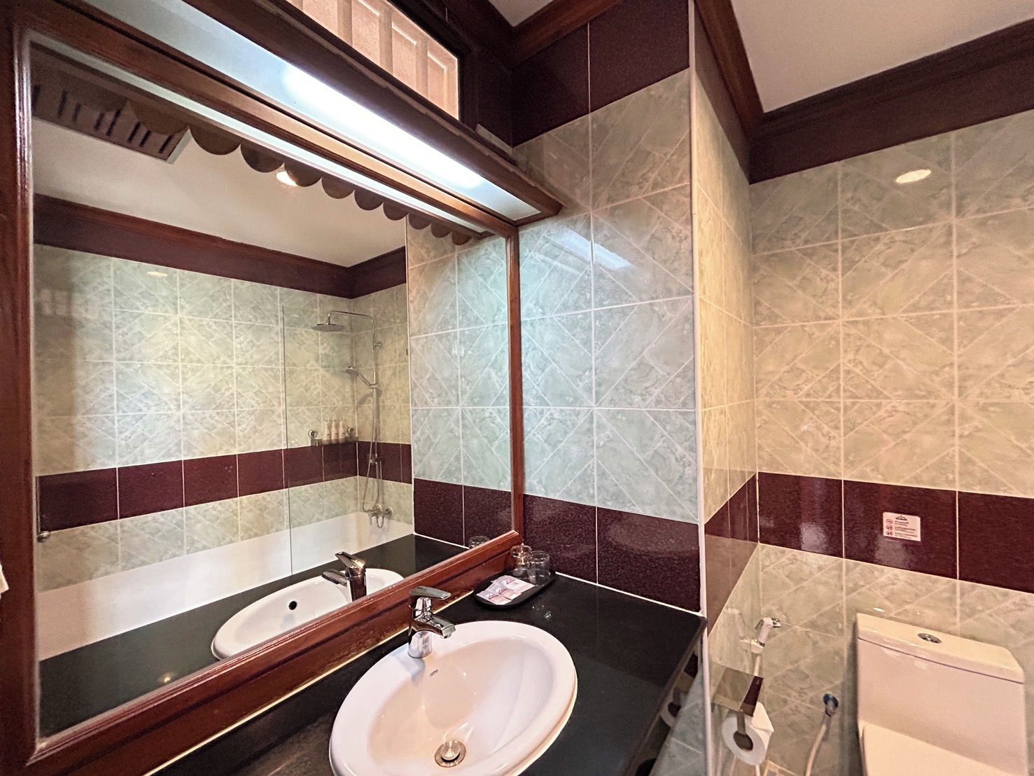 A bathroom with a sink, mirror, and shower.