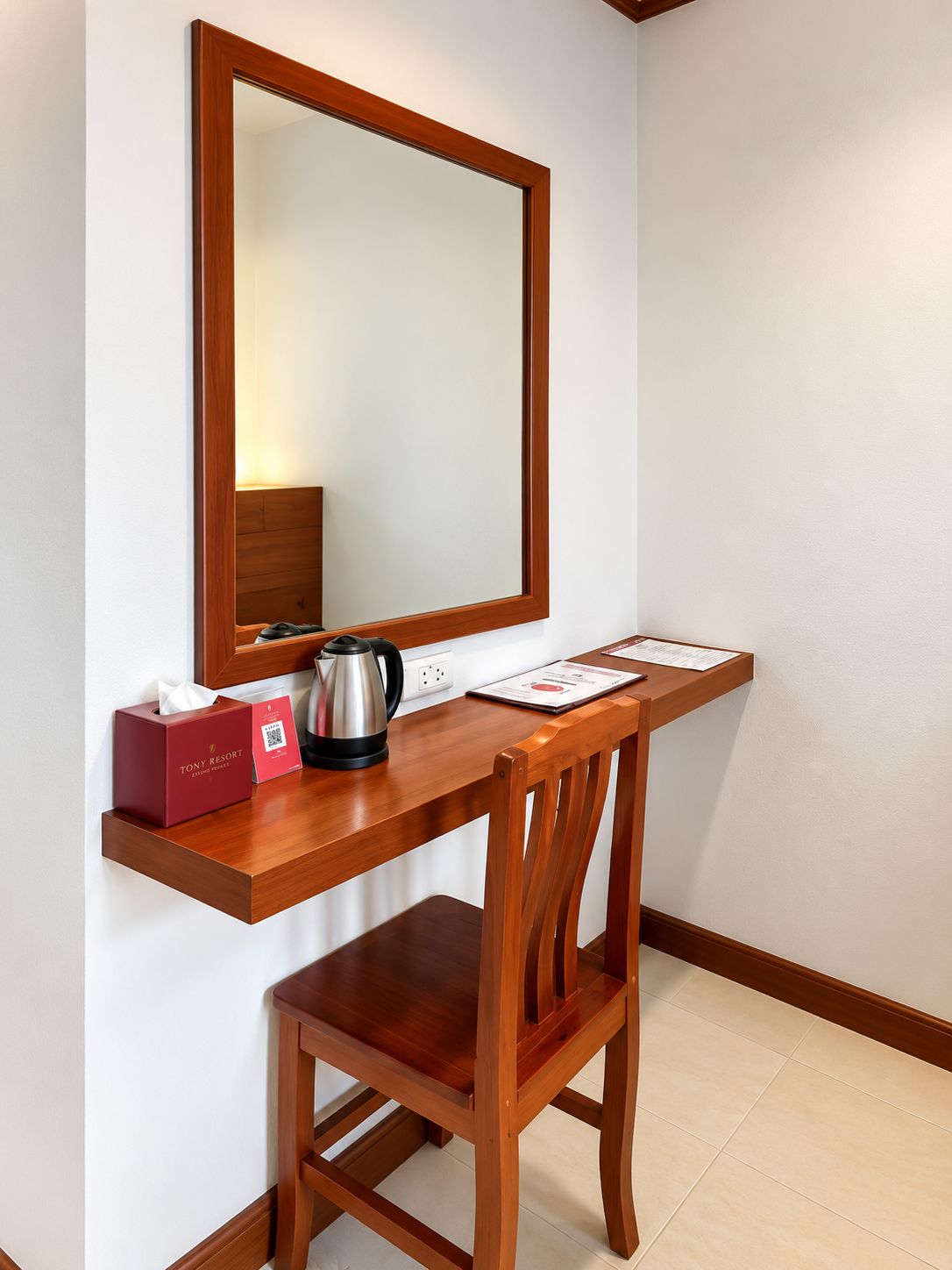 Uma mesa de madeira com um espelho, uma chaleira, uma caixa de lenços e um cardápio.