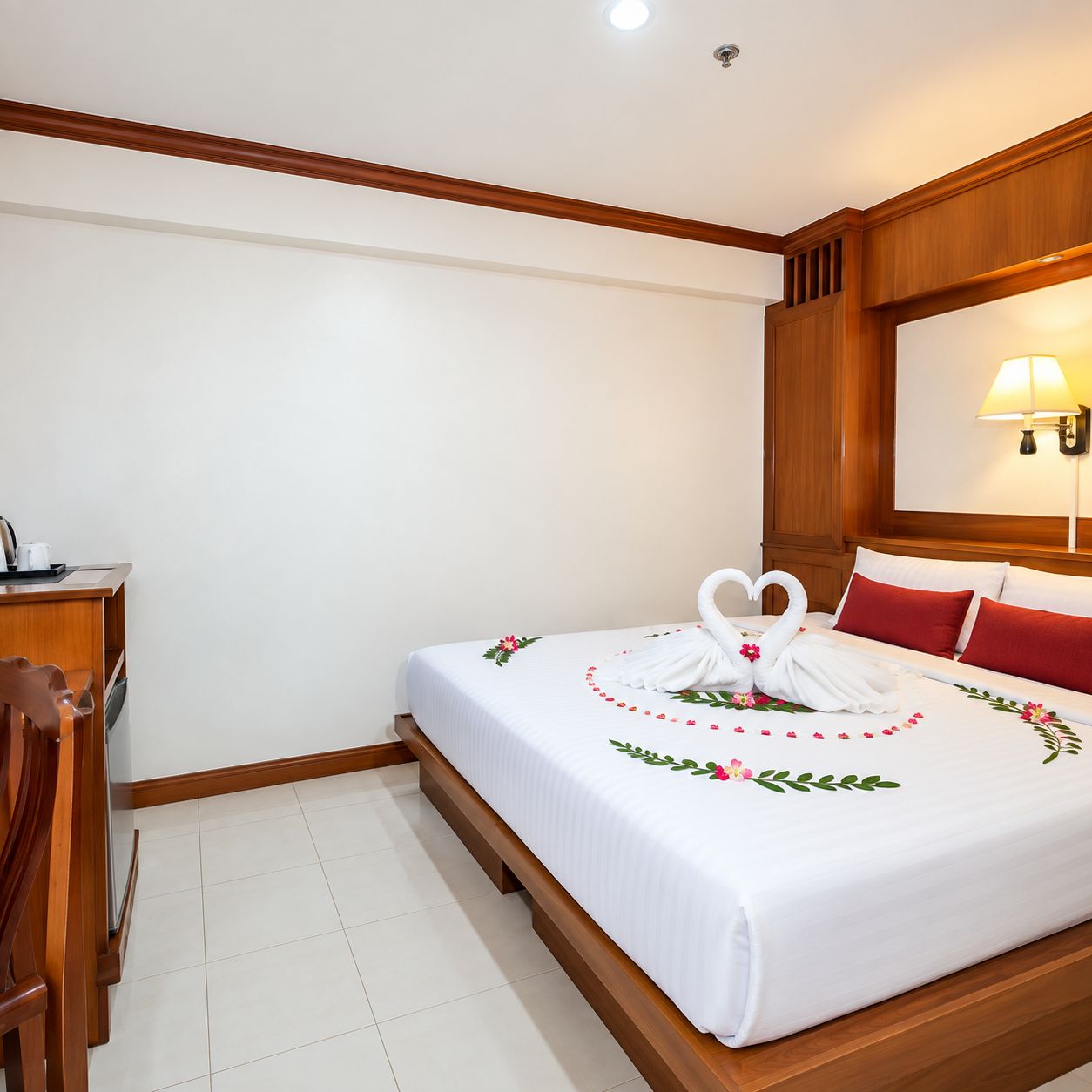 A hotel room with a bed, a desk, and a chair.