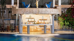 A poolside bar area with a statue, a variety of bottles, and a seating arrangement. - Tony Resort (Patong)