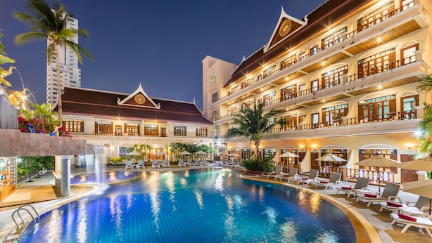 A hotel with a large indoor swimming pool, multiple balconies, and a traditional architectural style. - Tony Resort (Patong)