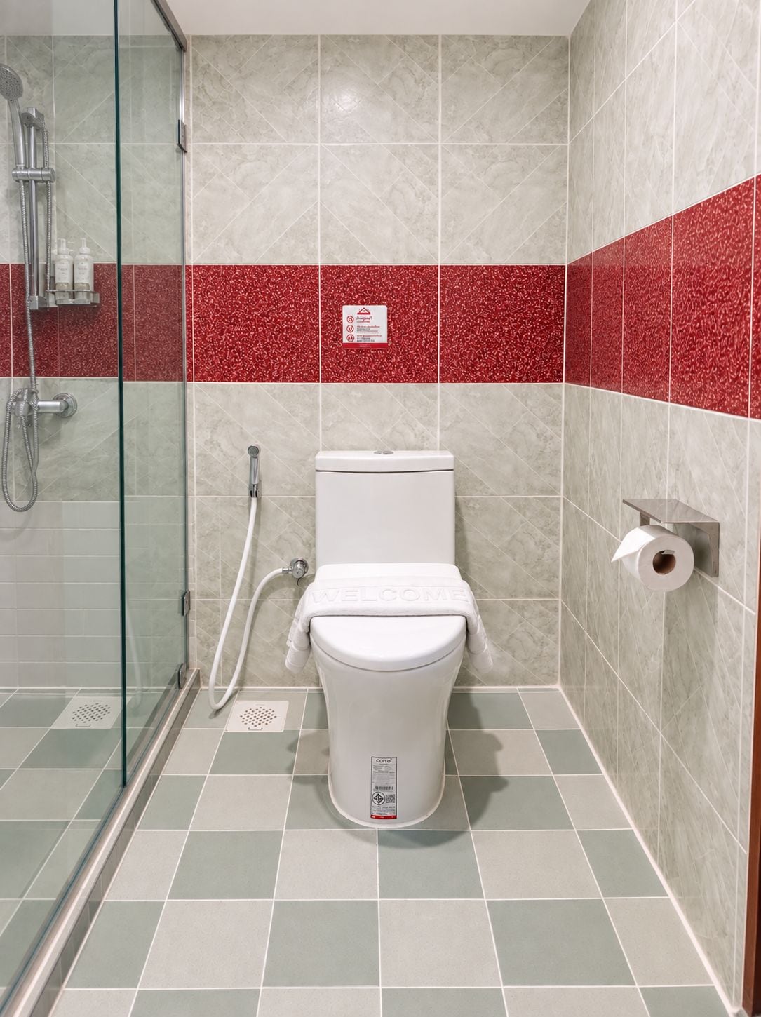 A bathroom with a toilet, shower, and glass-enclosed shower stall.