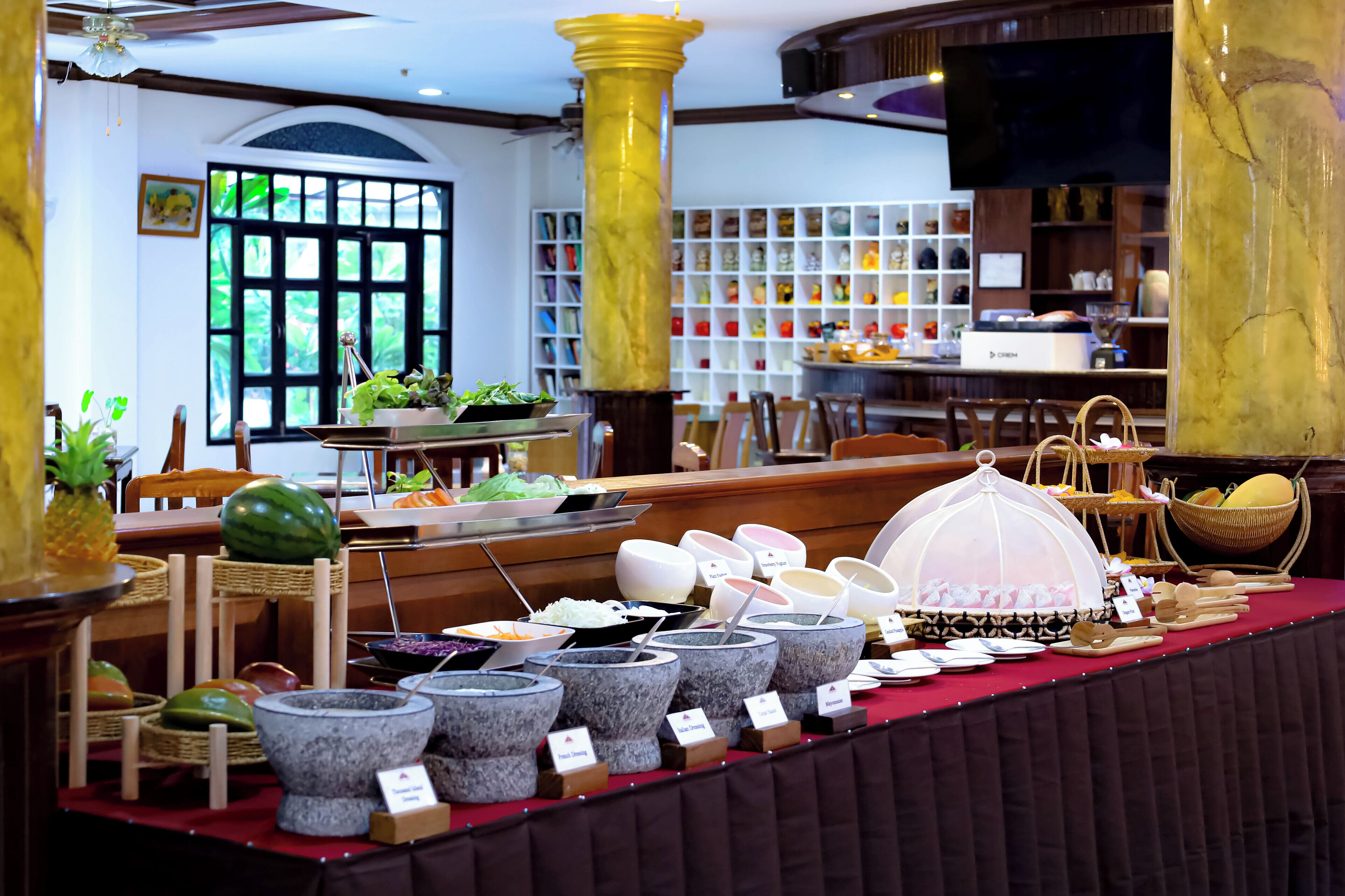 Montaje de bufé con diversos recipientes de comida, frutas y verduras.