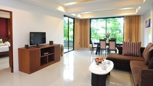 A modern living room with a flat-screen TV, wooden entertainment unit, and a brown sofa. - Samui Honey Tara Villa Residence (Koh Samui)