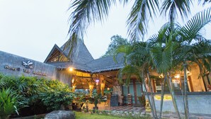 A restaurant with a thatched roof, a reception area, and tropical landscaping. - Samui Honey Tara Villa Residence (Koh Samui)