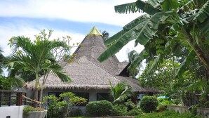 A thatched-roof building surrounded by lush greenery and a paved pathway. - Samui Honey Tara Villa Residence (Koh Samui)