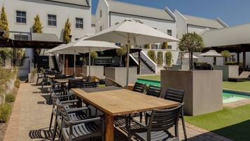 Alberca al aire libre, sombrillas en la alberca y camastros