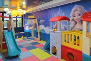 A children's play area with a slide, swings, and a playhouse. - Amata Patong (Patong)